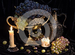 Still life with grape in vase and candles
