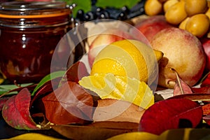 Still life with grapes, nectarines, lemon, jam and autumn leaves. Autumn harvest season. Fresh delicious healthy fruits