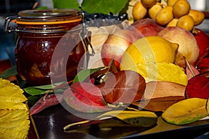 Still life with grapes, nectarines, lemon, jam and autumn leaves. Autumn harvest season. Fresh delicious healthy fruits