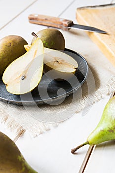 still life, green pears in a metal plate on a white wooden table