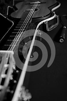 Still life with a guitar in a case and a dynamic microphone in black and white