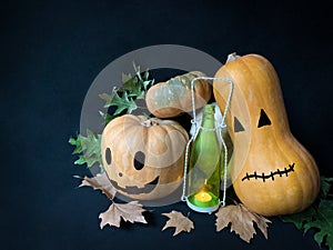 Still life Halloween pumpkins with a glowing candle in a bottle and autumn leaves