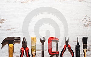 A still-life of handy tools on a rustic white wood background. Top view with copy space. Home DIY background concept