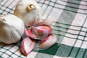 Still life of a head of garlic next to some loose teeth