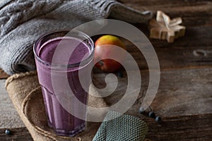 Still life of a healthy breakfast smoothie on wooden table with wool sweater