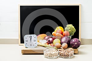 Still life with healthy food, a clock and a blackboard with space for copying