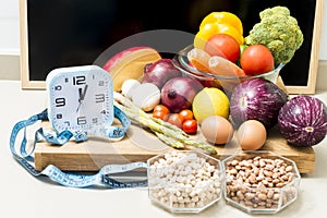 Still life with healthy food, a clock, a tape measure, and a blackboard