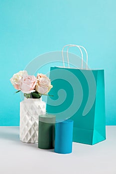Still life image with flower in vase, candle and paper bag. Mockup of craft shopping bags. Concept for sales or discounts.