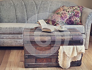 Still life interior details, book and cup of tea on old trunk