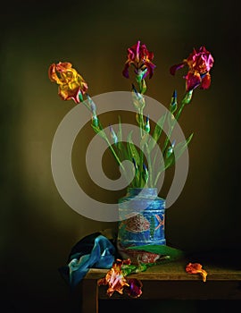 Still life with iris flowers in a blue vase.