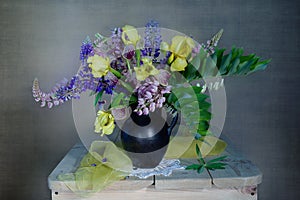 Still life with irises and lupines in a vase on the table