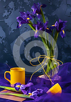 Still-life with irises, yellow cup and lemon on a purple background.