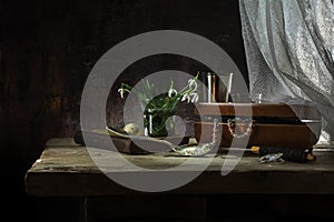 Still life with jewelery box, old book and snowdrop flowers on a