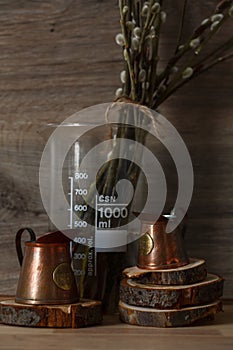 Still-life. Kitchen interior. copper measuring cups on wooden circles with willow branches on a wooden table