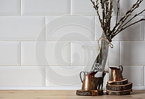 Still-life. Kitchen interior. copper measuring cups on wooden circles with willow branches on a wooden table