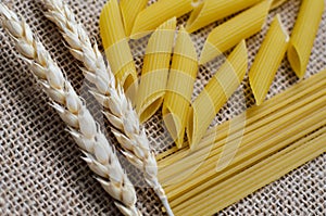 Still life for a kitchen of wheat ears and pasta from wheat on a sackcloth background Made in Kazakhstan