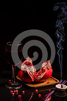 Still-life. A large red pomegranate on a wooden plate