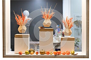 Still life with levitating pots with dry grass and artificial fruit