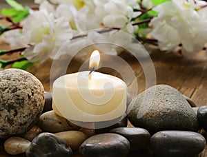 Still life a lit candle and stones