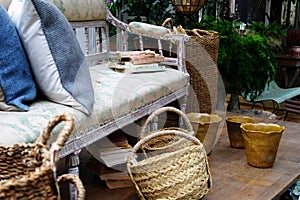 Still life living room with wooden sofa, basket, cushions and books.