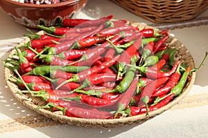 Still life with lots of red hot chili peppers in a wicker basket, oudoor shot