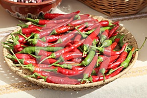 Still life with lots of red hot chili peppers in a wicker basket, oudoor shot photo