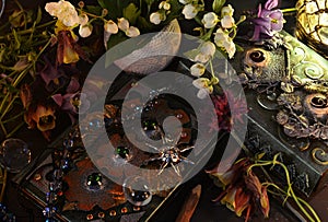 Still life with magic book of spells and beautiful flowers on witch ritual table.