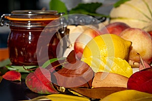 Still life with melon, nectarines, jam and autumn leaves. Autumn harvest season. Fresh delicious healthy fruits, contain