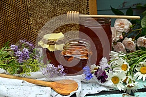 Still life with natural honey in jar, dipper, flowers and stick on wooden background outside. Countryside summer rural background