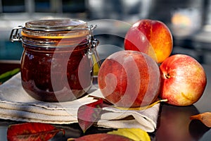 Still life with nectarines, jam and autumn leaves. Autumn harvest season. Fresh delicious healthy fruits, contain