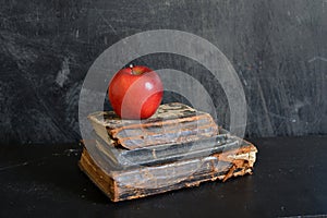 Still life with Old damaged holy bibles and red apple