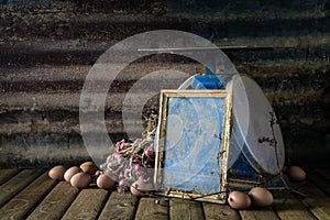 Still life with old frame, eggs, onions, and old blue scales