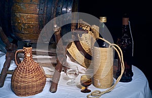 Still life with old oak wine barrel, bottles and smiley on black background