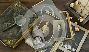 Still-life with old photo album and historical photos of family.