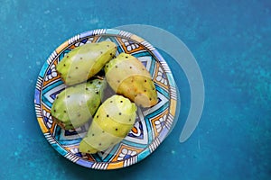 Still life with opuntia cacti fruit on blue decorative plate