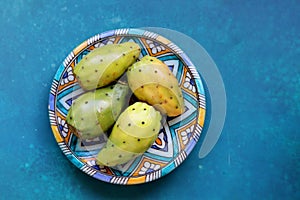 Still life with opuntia cacti fruit on blue decorative plate