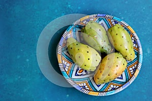 Still life with opuntia cacti fruit on blue decorative plate
