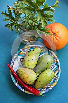 Still life with opuntia cacti fruit on blue decorative plate