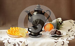 Still life with oranges, sweets and coffee service