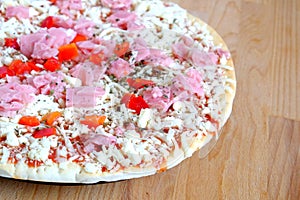 Part of raw pizza on brown kitchen table top view closeup photo