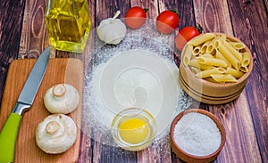 Still life with pasta ingredients on wooden background