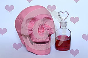 a pastel pink skull and love potion with a hearts pattern background
