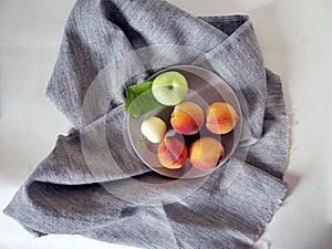 Still life of peaches, apples, leaves on a light background, top view