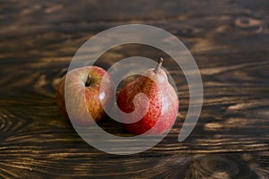 Still life. Pear and apple on a brown background, on a cutting board.