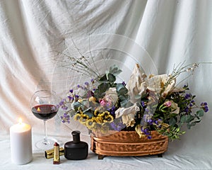 still life photo with beautiful dry colorful flowers in a vase, cosmetic accessories