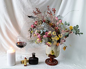 still life photo with beautiful dry colorful flowers in a vase, cosmetic accessories