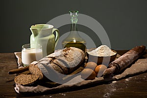 Still life photo of bread and flour with milk and eggs