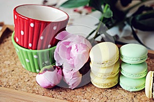 Still-life photo with cups, macaroons and peony