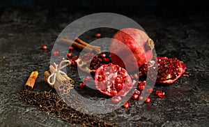 Still life photo of pomegranade and cinamon aromated dry tea leafs on the grunge background photo