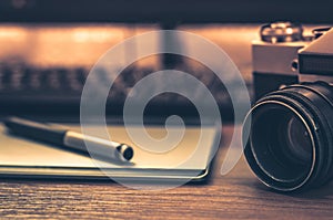 Still life of photographer desk in home office interior. Professional photo media working equipment, camera body, lenses, monitor